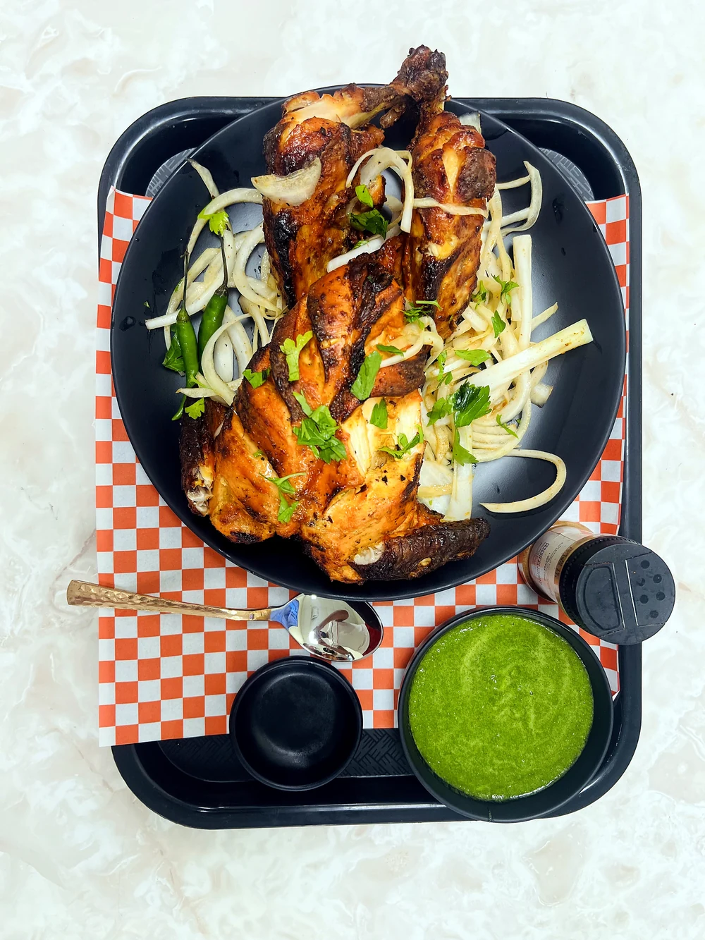 Seasoned cooked pieces with onions, citrus and green chutney at Lutf Indo-Pak Cuisine